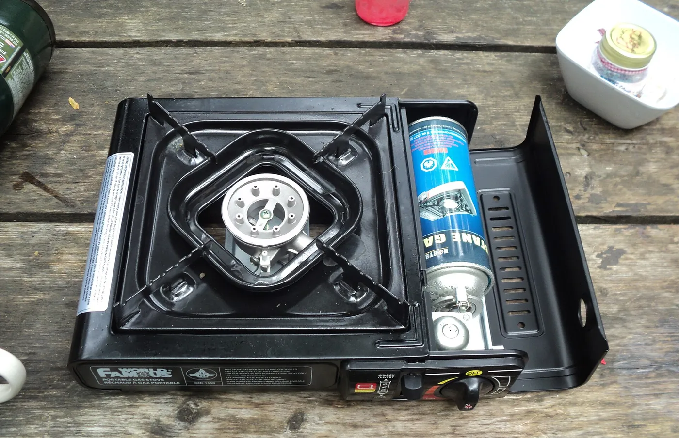Réchaud à cartouche de gaz type cassette posé sur une table en bois
