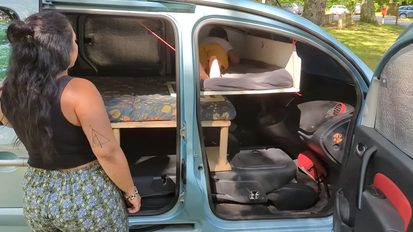 Vue latérale d'un Kangoo 2 aménagé avec lit adulte et lit enfant